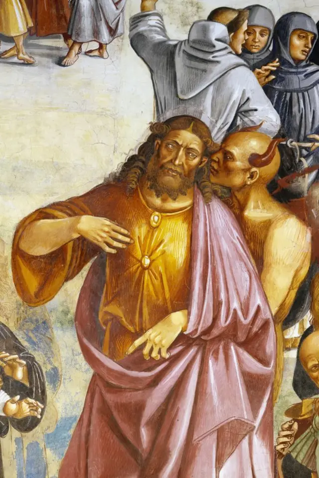 Detalhe do afresco dos Feitos do Anticristo (1499-1504) de Luca Signorelli, na catedral de Orvieto, na Itália, ilustrando Satã com chifres, cochichando no ouvido do Anticristo, retratado de forma similar a Jesus, com barba, cabelos longos e manto esvoaçante